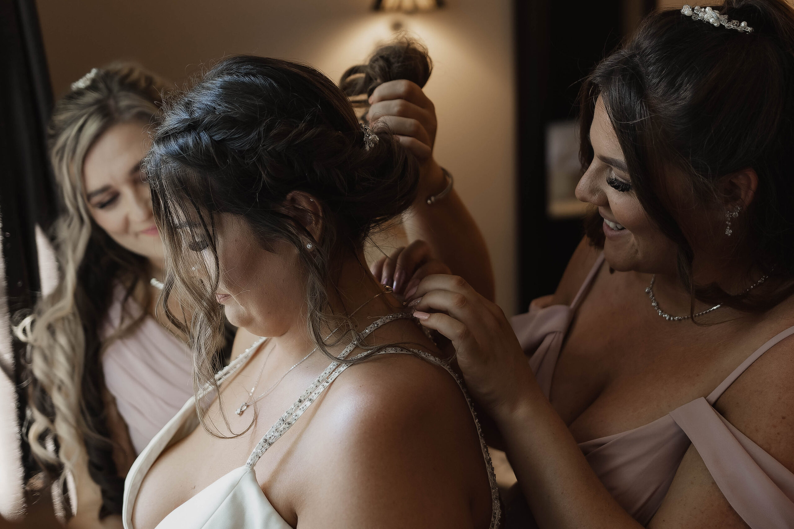A intimate photo of a bride getting ready with bridesmaids at a Hampshire hotel, captured by a documentary-style wedding photographer.