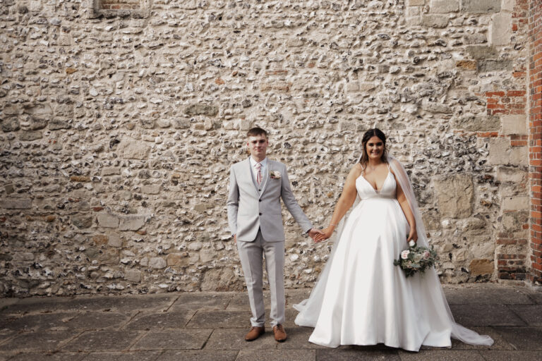 A candid photo of a couple laughing and hugging during their wedding ceremony, captured by a documentary-style photographer in Hampshire.